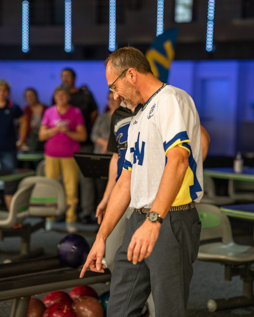 Photo d'Éric Courault pointant du doigt une boule de bowling